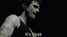 a man with a mustache is singing on a stage and the words `` it 's peak '' are visible .
