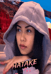 a woman wearing a hooded sweatshirt with the word hatake on it