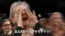 a woman is screaming in a crowd while covering her face with her hands .
