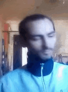 a man with a beard is wearing a blue jacket and headphones
