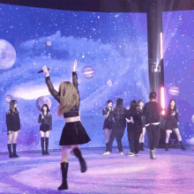 a woman in a black skirt is holding a microphone in front of a large screen