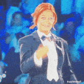 a woman wearing a tuxedo and bow tie is on a television screen with trashtvtroll written below her