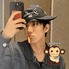 a man taking a picture of himself with a hat that says intak on it