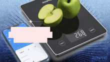 a renpho scale with two apples on it and a phone next to it
