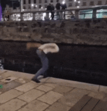 a man is jumping into a body of water at night