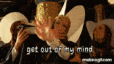 a group of people are standing around a woman wearing a hat that says " get out of my mind "