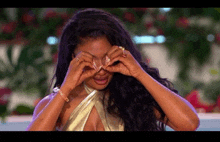a woman in a gold dress is covering her eyes with her hands while crying .