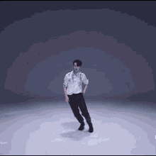 a man in a white shirt and black pants is dancing in front of a album