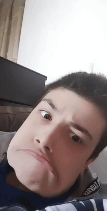 a young man is making a funny face with his eyes closed