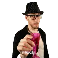 a man wearing a hat and glasses is holding a pink wine glass with the word mcdh on the bottom right