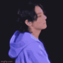 a blurry picture of a person wearing a purple hoodie .