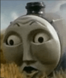 a cartoon train with a surprised look on its face is standing in a field .