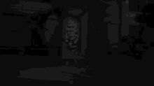 a man is standing in a dark room in front of a white box .