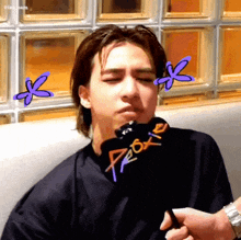 a man is sitting on a couch with his eyes closed and a microphone in front of him .