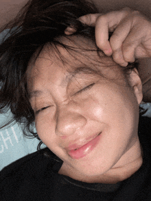a close up of a woman 's face with her eyes closed and the word hi visible in the background