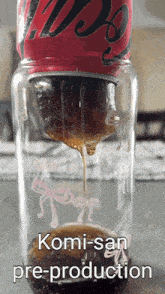a can of coca cola is being poured into a glass bottle