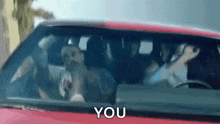 a group of people are sitting in a car with the words `` you '' written on the windshield .