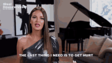 a woman says " the last thing i need is to get hurt " while standing in front of a piano