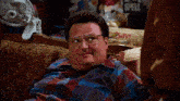 a man with glasses sits on a couch with the words i need a really pretty face above him
