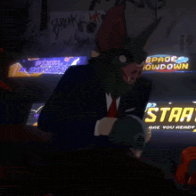 a man with a bat mask is sitting in front of a sign that says start