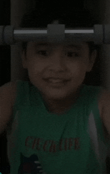 a young boy wearing a green chuck life shirt