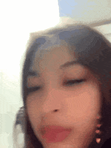 a close up of a girl 's face with her eyes closed and earrings .