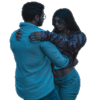 a man in a blue shirt is hugging a woman wearing sunglasses