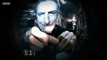 a bbc screen shows a man pointing a gun