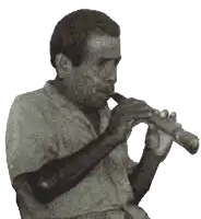 a man playing a flute in a black and white photo