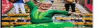a man in a green dress is dancing on stairs .