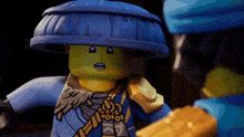 a lego character wearing a blue hat and a gold glove