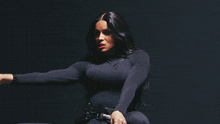 a woman in a black outfit is making a face