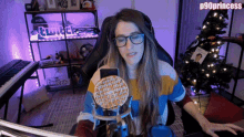 a woman sitting in front of a computer with a waffle in front of a microphone with the name p90princess on the bottom