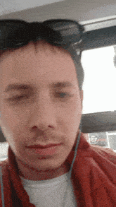 a man wearing sunglasses and ear buds is looking at the camera