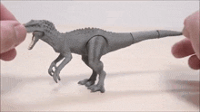a toy dinosaur is being held by a person
