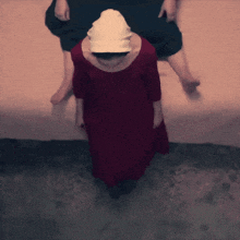 a woman in a red dress and white hat is standing in front of a man