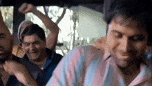 a group of men are sitting in a car laughing and dancing .