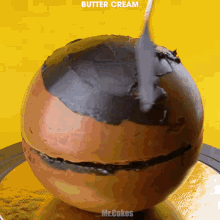 a chocolate ball with butter cream being spread on top of it