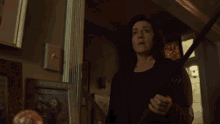 a woman in a brown jacket holds a sword in a hallway with a sign that says fox