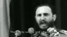 a man is speaking into a microphone with the words that is why we say and we proclaim behind him