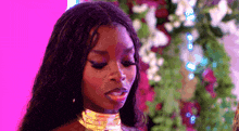 a close up of a woman wearing a choker and earrings .