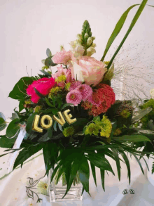 a bouquet of flowers with the word love in gold