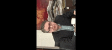 a man wearing glasses is sitting at a table with a sign that says mnie pocalowac