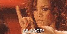 a woman with curly hair is looking at herself in a mirror and says `` be good '' .