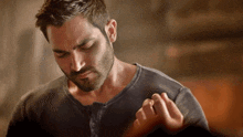 a man with a beard is holding a woman 's hand and looking down at her .