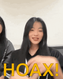 a girl is making a funny face in front of a hoax sign