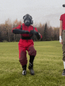 a man in a gas mask is standing in a field