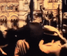 a crowd of people are gathered in front of a building that says 24 ack on it