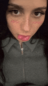 a close up of a woman 's face with her tongue hanging out
