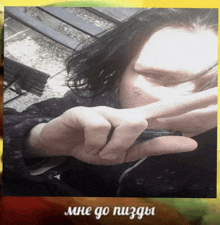 a person with a tattoo on their face is holding a pen in their hand with the words mne go nuzda on the bottom